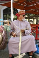 An elderly man using palm leaf strands to weave baskets. Credit: Tone Delin Indrelid